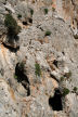Kalymnos - detail of the crag behind Emborios showing the dressed stone construction of the Kastri and the cave openings
