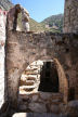 Nisyros - the inner courtyard of Siones looking through the bell arch of the chapel towards the steps up to the flat roof and the main entrance to the complex